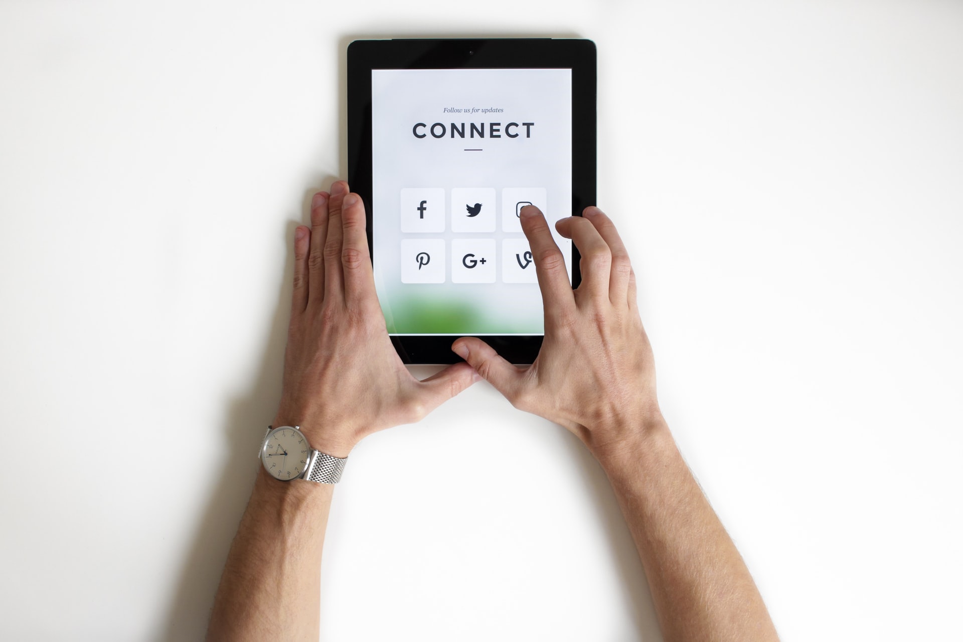vídeo marketing: duas mãos masculinas interagindo com um tablet conectado às redes sociais